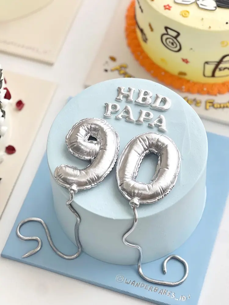 Cake biru muda bertuliskan HBD PAPA dengan balon angka 90 perak