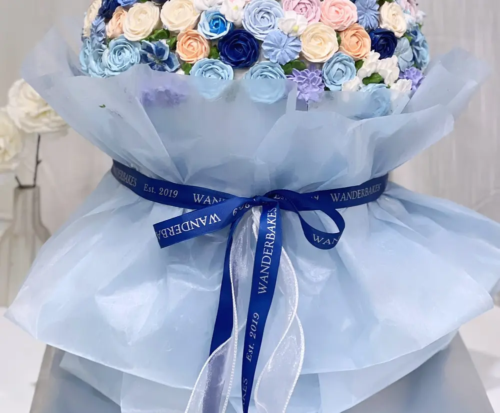 Bouquet cake bunga buttercream biru dan peach dengan pita Wanderbakes
