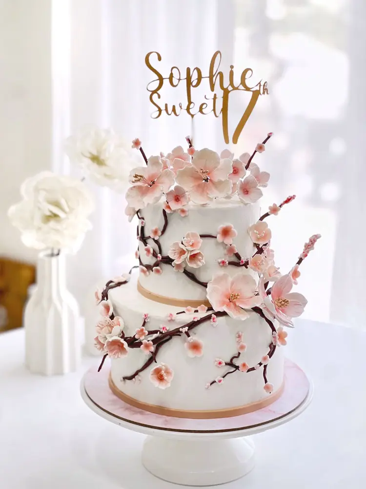 Cake dua tingkat putih dengan bunga sakura merah muda