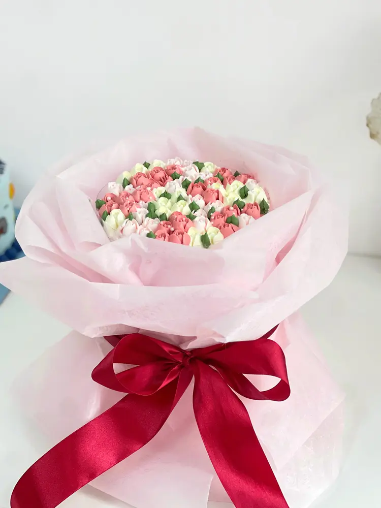 Bouquet cake berbungkus kertas pink dengan pita merah
